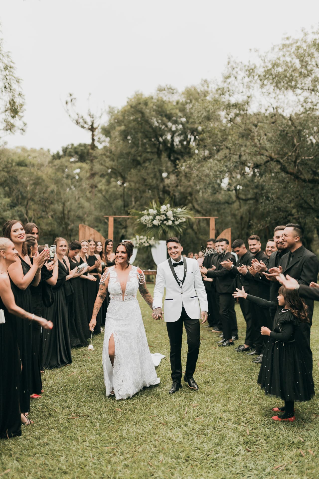 Newlyweds walking back down the aisle as guests applaud