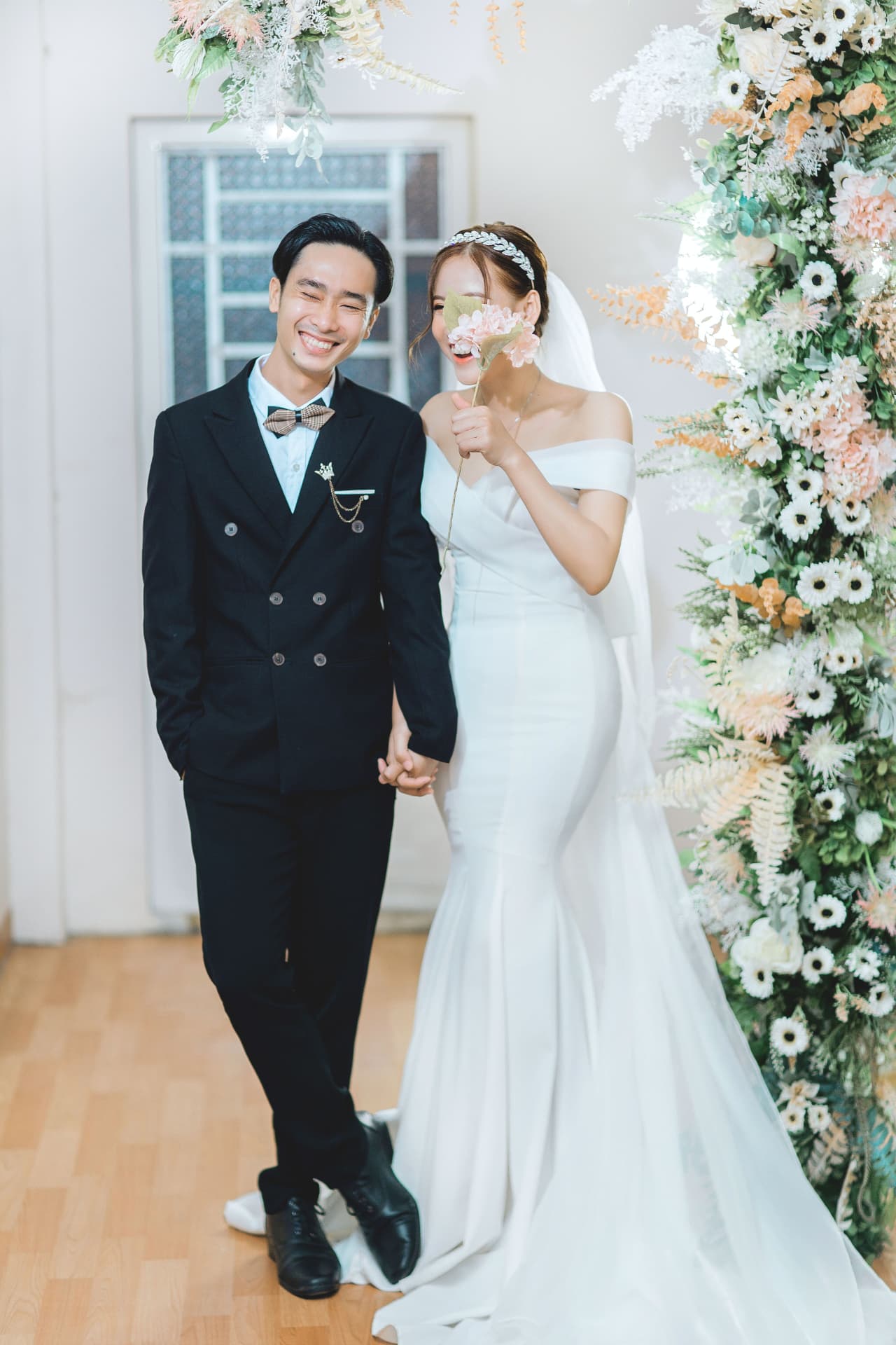 Bride and groom beside a floral installation before the ceremony